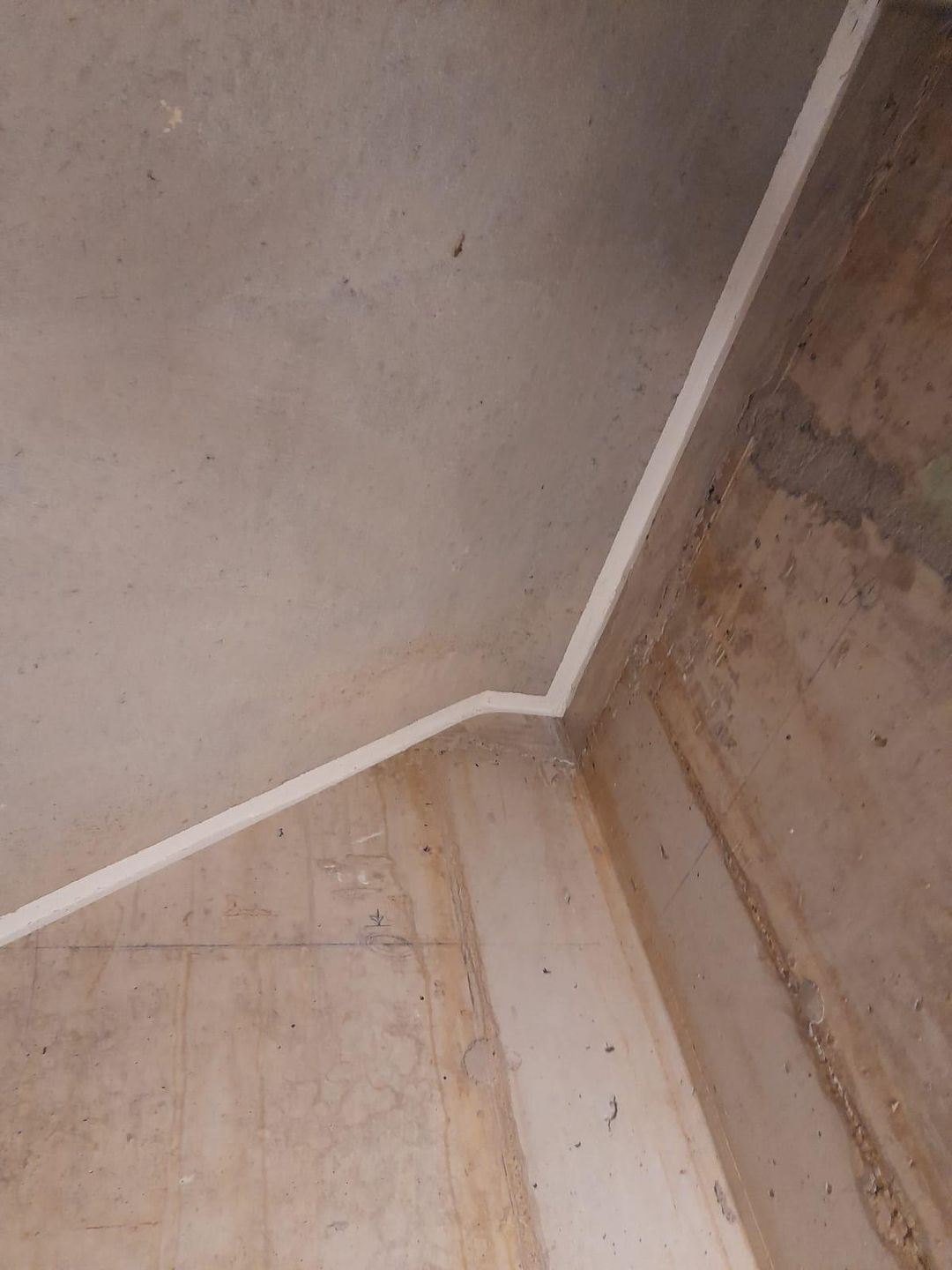 Weiss abgedichtete Anschlussfuge zwischen Wand und Boden im Rohbau