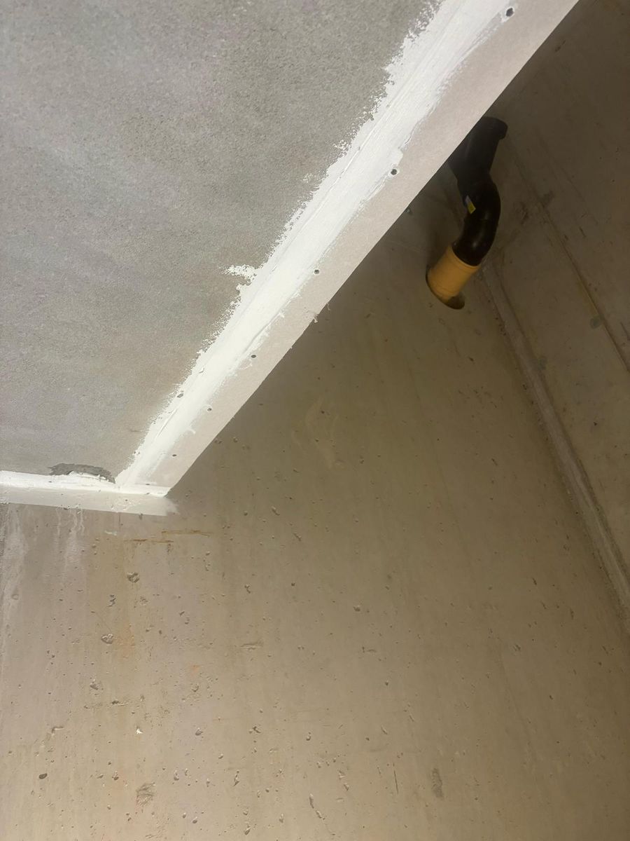 Abgedichtete Fuge zwischen Betondecke und Wand mit sichtbarer Rohrdurchführung